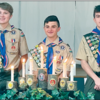 From left, Jack Pfeffer, Camren Ferri and Connor Cooper pose with their red, white and blue Eagle
Scout neckerchiefs and badges. (by the candles and logs symbolizing their trial to Eagle)