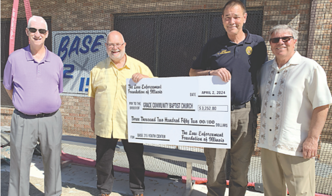 Above Trenton mayor Andy Weh, Pastor Bob Marsh, Trenton Chief of Police Chris Jollenbeck and
Base 215 Director Alan Zurliene, display the “big check” depicting the grant amount recently received through the Law Enforcement Foundation of Illinois.