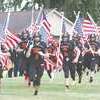 The Warriors take the field carrying the symbolic 13 American flags.